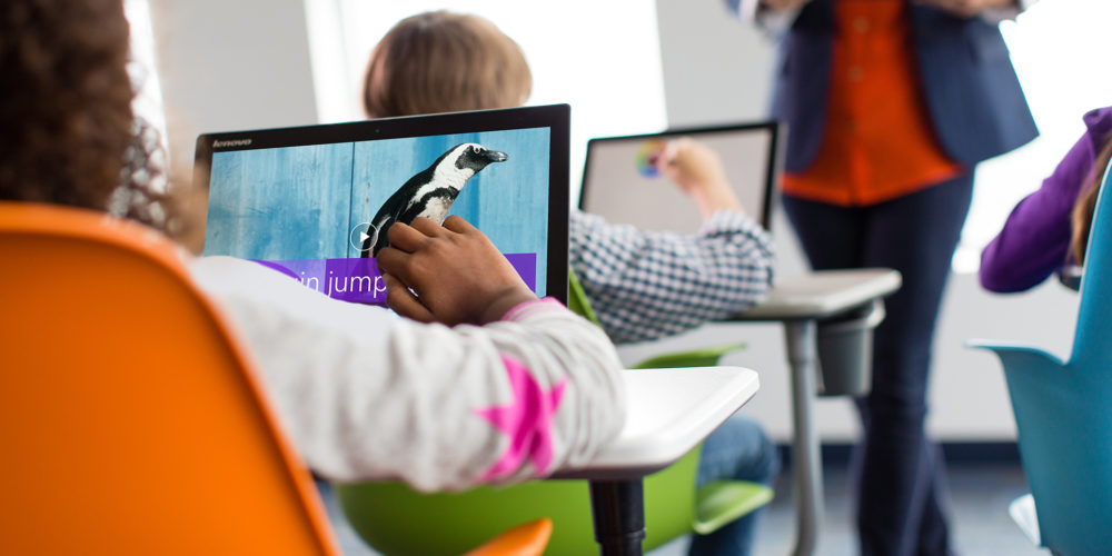 A child using a microsoft interface in a classroom environment to get creative.